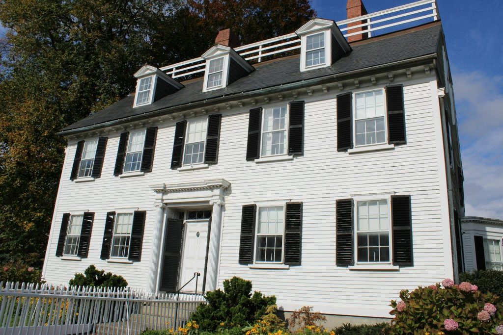 A white colonial house with black shutters